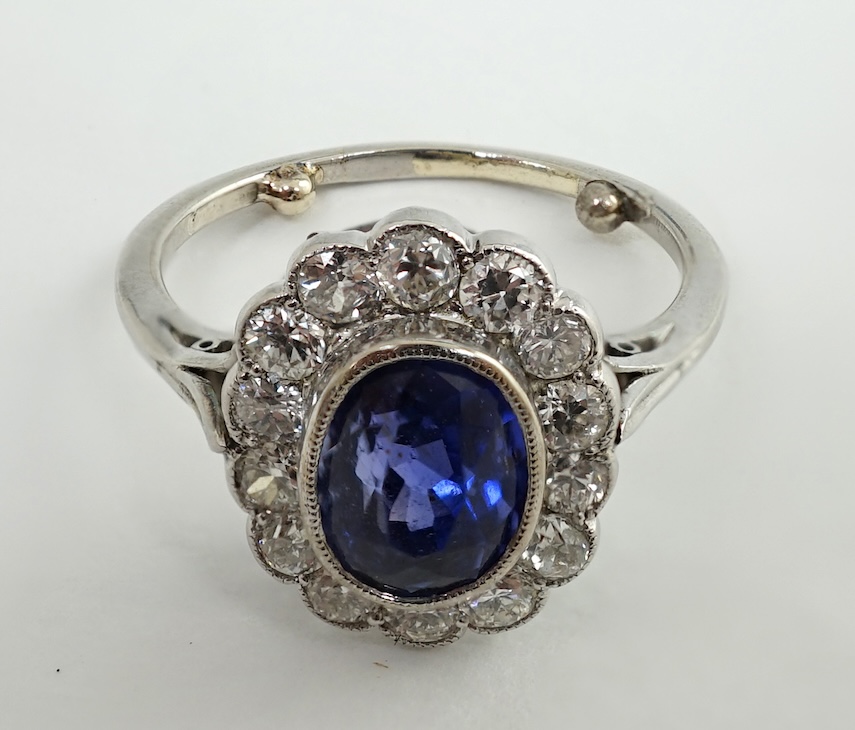 A mid 20th century white gold and millegrain set sapphire and diamond oval cluster ring